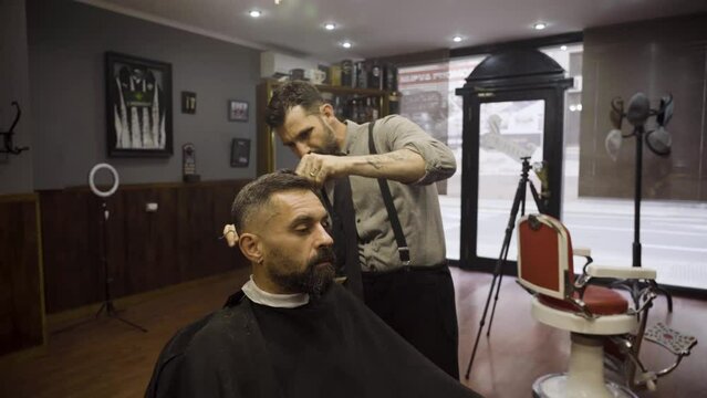 Professional Barber Cuts Hair Of His Client With Scissors - close up