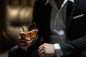 Businessman sitting Holding a Glass of Whiskey Drink Whiskey in the liquor store room