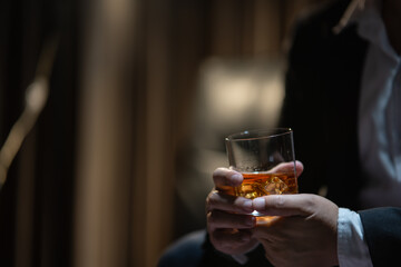 Businessman sitting Holding a Glass of Whiskey Drink Whiskey in the liquor store room