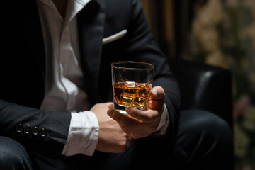 Businessman sitting Holding a Glass of Whiskey Drink Whiskey in the liquor store room
