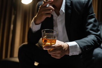 Businessman sitting Holding a Glass of Whiskey Drink Whiskey in the liquor store room
