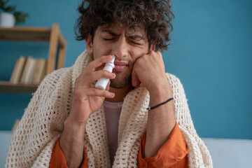 Illness and sickness concept. Handsome arabic guy feeling sick dripping nasal drops in blocked...