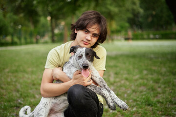 Outdoor portrait of boy with his adopted dog. Friendship of teenager with pet, boy walking in...