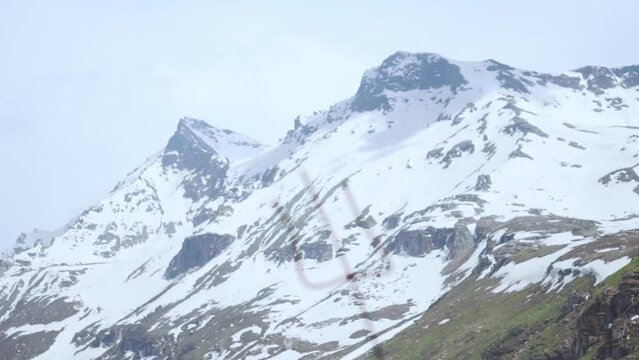 Rack focus of Shiva Trishul in background of snow covered Himalaya mountains at Manali in Himachal Pradesh, India. "Trishul" In indian Himalaya. mountains and trisula weapon for shivratri festival