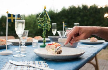 person eating traditional Swedish food outdoors at a party