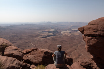 Fototapeta na wymiar Woman sitting down taking in the view of Canyonlands National Park