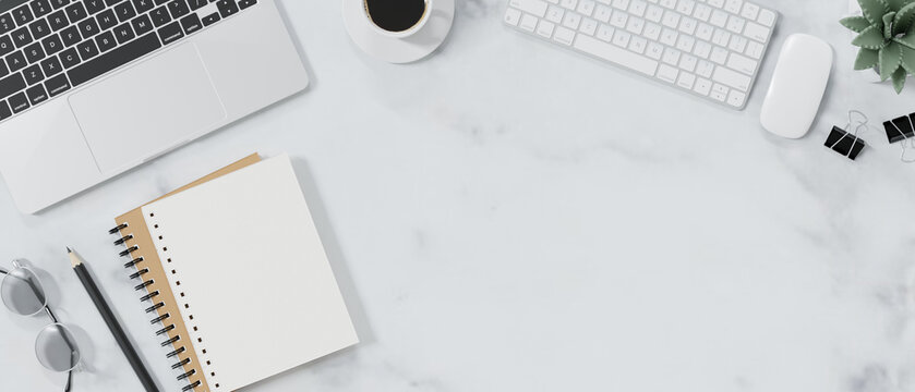 Top view of modern workspace with blank notebook, office supplies and copy space.