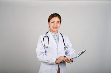 Portrait of young confident female doctor standing with white isolated background.