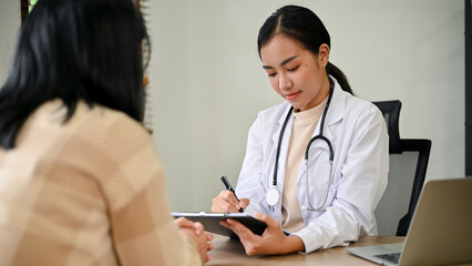 Young female doctor diagnose female patient in her clinic room.