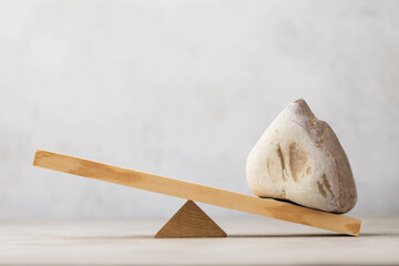 Stone on wooden swing or scales on abstract background, template for designer
