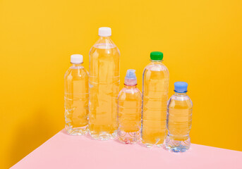 Water in plastic bottles of different sizes on the table.