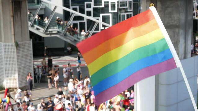 view of gay LGBTQ+ pride flag waving at pride parade festival in the city.people waving the gay pride flag to celebrate the pride of being equality and freedom.