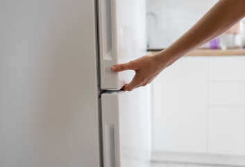 hand is opening refrigerator door
