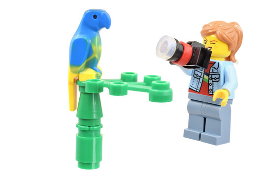 Lego  minifigure photograph is taking a picture, funny and cheerful face grimace. Editorial illustrative image of popular children plastic toy.