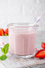 Strawberry milkshake or smoothie cocktail in the glass jar on a gray concrete background. Copy space.