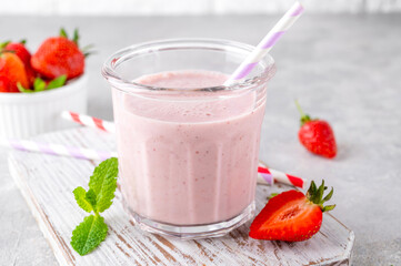 Strawberry milkshake or smoothie cocktail in the glass jar on a gray concrete background. Copy space.