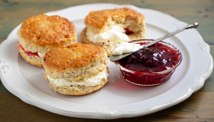 Traditional british scones with clotted cream and strawberry jam for tea time