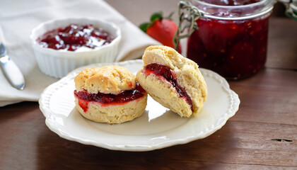Traditional british scones with clotted cream and strawberry jam for tea time