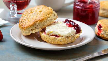 Traditional british scones with clotted cream and strawberry jam for tea time