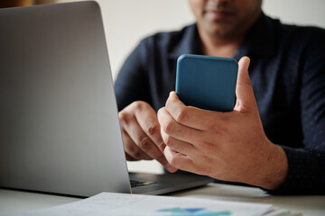 Closeup image of businessman checking daily planner application on smartphone