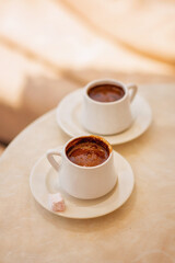 Cup of hot coffee on table by the blue pool on a sunny summer day. cozy warm mood, brown tones. Black coffee in traditional Turkish cup. turkish coffee