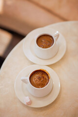 Cup of hot coffee on table by the blue pool on a sunny summer day. cozy warm mood, brown tones. Black coffee in traditional Turkish cup. turkish coffee