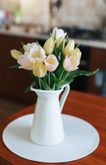 Spring tulips in a vase on the table. Spring holiday, home decor.