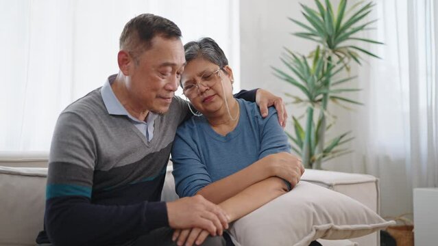 Asian elderly old couple embracing bonding comforting and express empathy. Elderly man caring wife holding hands supporting giving sympathy loving. Couple retirement lifestyle