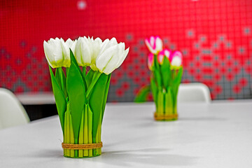 bouquet of white tulips on a table in a red interior. Festive mood