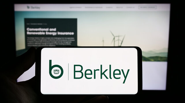 Stuttgart, Germany - 06-24-2023: Person holding smartphone with logo of US insurance company W. R. Berkley Corporation on screen in front of website. Focus on phone display.