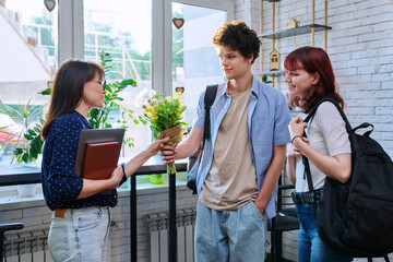 College students and female mentor teacher with bouquet of flowers
