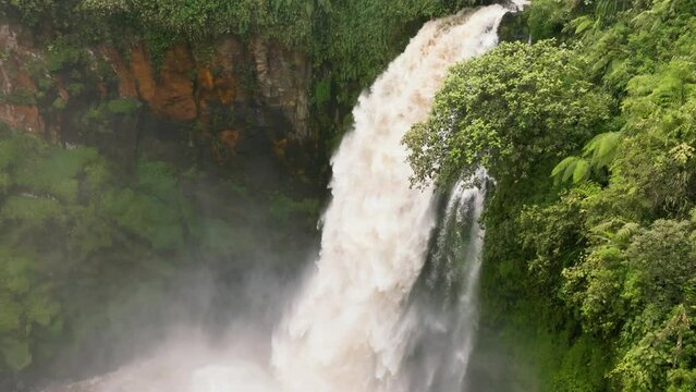Aerial view of Telun Berasap Falls in green forest. Waterfall in the jungle in slow motion. Sumatra, Jambi, Indonesia.