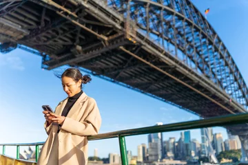 Foto auf Acrylglas Sydney Asian woman using mobile phone during travel on ferry boat crossing harbor in Sydney, Australia. Attractive girl enjoy urban outdoor lifestyle travel in the city with gadget device on holiday vacation
