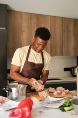 Fototapeta na wymiar Young black man preparing a chicken mince recipe in a kitchen.