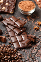 Handmade chocolate, cocoa powder and spices on a dark background