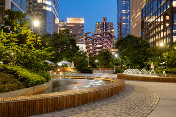 Park and fountains at Hudson Yards building complex in evening. Summer in Midtown West, Manhattan, New York City