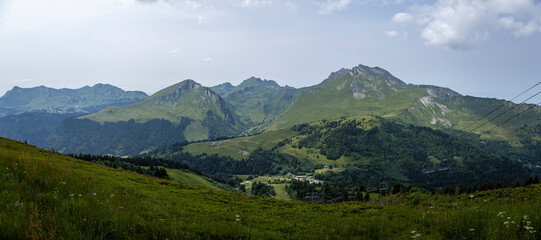 Wide panorama view from the top of Belvedere showing green slopes of Alpine lanscape with French Alps during summer. Outdoor mountainous sports. 