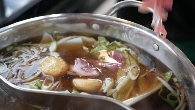 Chinese spicy hot pot cuisine while cooking meatball, fishball and wanton in hot boil chinese style soupbase
