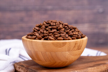 Coffee bean on wood background. Coffee bean in wooden bowl. Close up