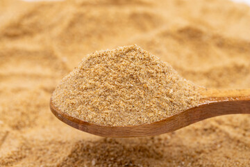 Breadcrumbs on wooden spoon. spice or seasoning as background. close-up breadcrumbs flour