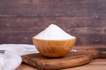 Sodium bicarbonate or baking soda on wood background. Sodium bicarbonate powder in wooden bowl