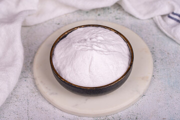 Fototapeta na wymiar Sodium bicarbonate or baking soda on grey background. Sodium bicarbonate powder in bowl