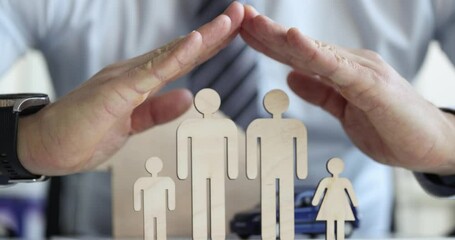 Male hands protecting wooden figurines of lgbt family closeup 4k movie slow motion. Homosexual couples rights advocacy concept