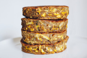 Delicious freshly cooked gluten free thick zucchini pancakes made with natural ingridients such as banana flour, eggs and summer squash. Healthy food with no gluten. Shallow depth of field.