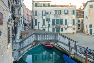 Fototapeta na wymiar Canal with stone bridge and historic buildings in Venice, Italy, Europe.