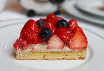 shining berry and strawberry cheese tart cake on white plate