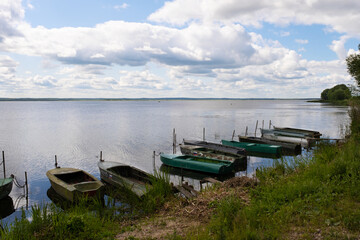 Fototapeta na wymiar Rostov, Russia - June 10, 2023. Boats on the shores of Lake Nero. Cloudy weather, beautiful sky.