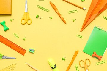Frame made of paper plane and different school stationery on yellow background