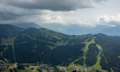 Looking down in valley with Les Gets outdoor sports holiday destination surrounded by the green...