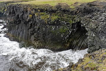 Naklejka na ściany i meble Waves washing against black basalt cliffs at Arnarstapi Cliffs in Snaefellsnes Peninsula, Iceland